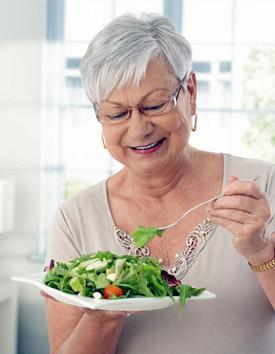 пожилая женщина ест салат